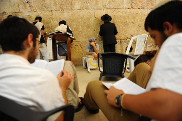 Orthdox Jews men pray as they gather for the ritual of Tisha B'Av at the Wall Western in the Old City of Jerusalem, July 25, 2015. The Tisha B'Av ceremony, literally the ninth day of the month of Av in the Hebraic calendar, is the darkest day in the Jewish calendar, marking the destruction of the two temples, first by the Babylonians in 587 BC and later by the Romans in 70 AD. Photo by Mendy Hechtman/Flash90. *** Local Caption *** ????? ???? ???? ??? ?????? ?????