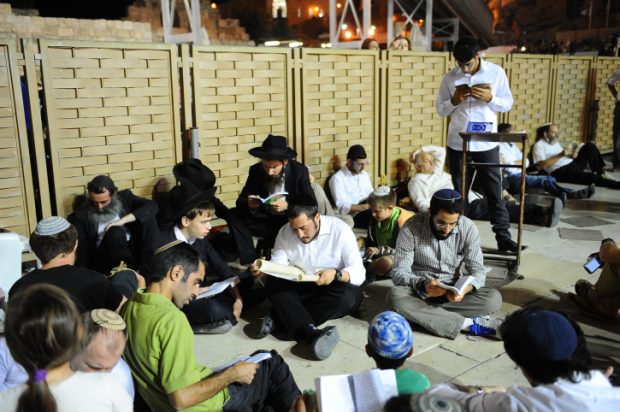 Orthdox Jews men pray as they gather for the ritual of Tisha B'Av at the Wall Western in the Old City of Jerusalem, July 25, 2015. The Tisha B'Av ceremony, literally the ninth day of the month of Av in the Hebraic calendar, is the darkest day in the Jewish calendar, marking the destruction of the two temples, first by the Babylonians in 587 BC and later by the Romans in 70 AD. Photo by Mendy Hechtman/Flash90. *** Local Caption *** ????? ???? ???? ??? ?????? ?????