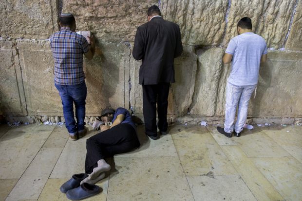 An Orthodox jewish man sleeps during the ritual prayer of Tisha B'Av at the Wall Western in the Old City of Jerusalem, early on July 26, 2015. The Tisha B'Av ceremony, literally the ninth day of the month of Av in the Hebraic calendar, is the darkest day in the Jewish calendar, marking the destruction of the two temples, first by the Babylonians in 587 BC and later by the Romans in 70 AD. Photo by Yonatan Sindel/Flash90. *** Local Caption *** ????? ???? ???? ??? ?????? ????? ???? ??? ????